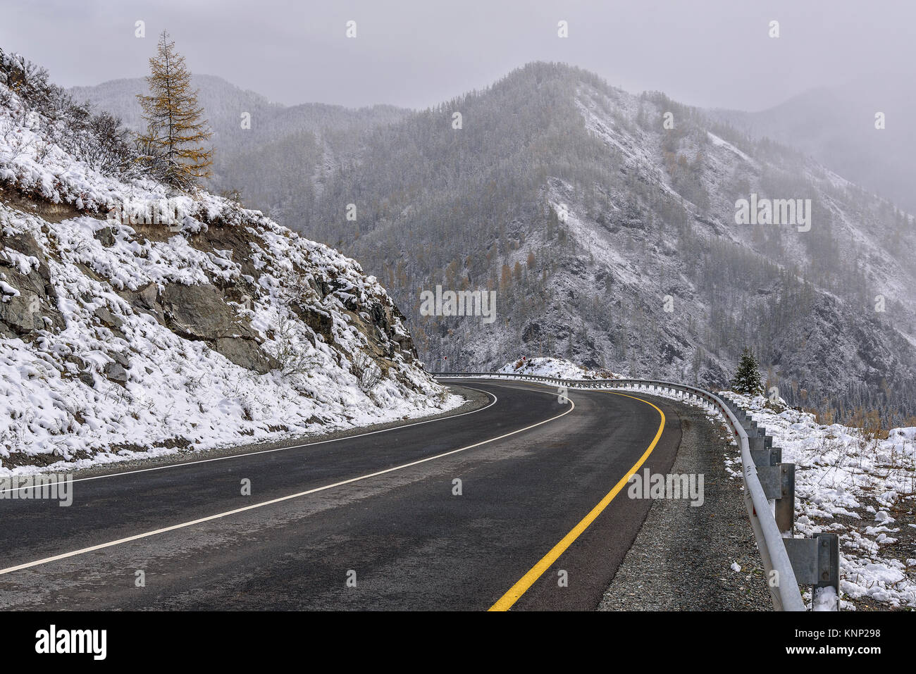 Malerischer Blick auf die Haarnadelkurve kurvenreiche Straße durch den Pass, Teil eines Berges Serpentine, im Herbst Wetter mit Schnee Stockfoto