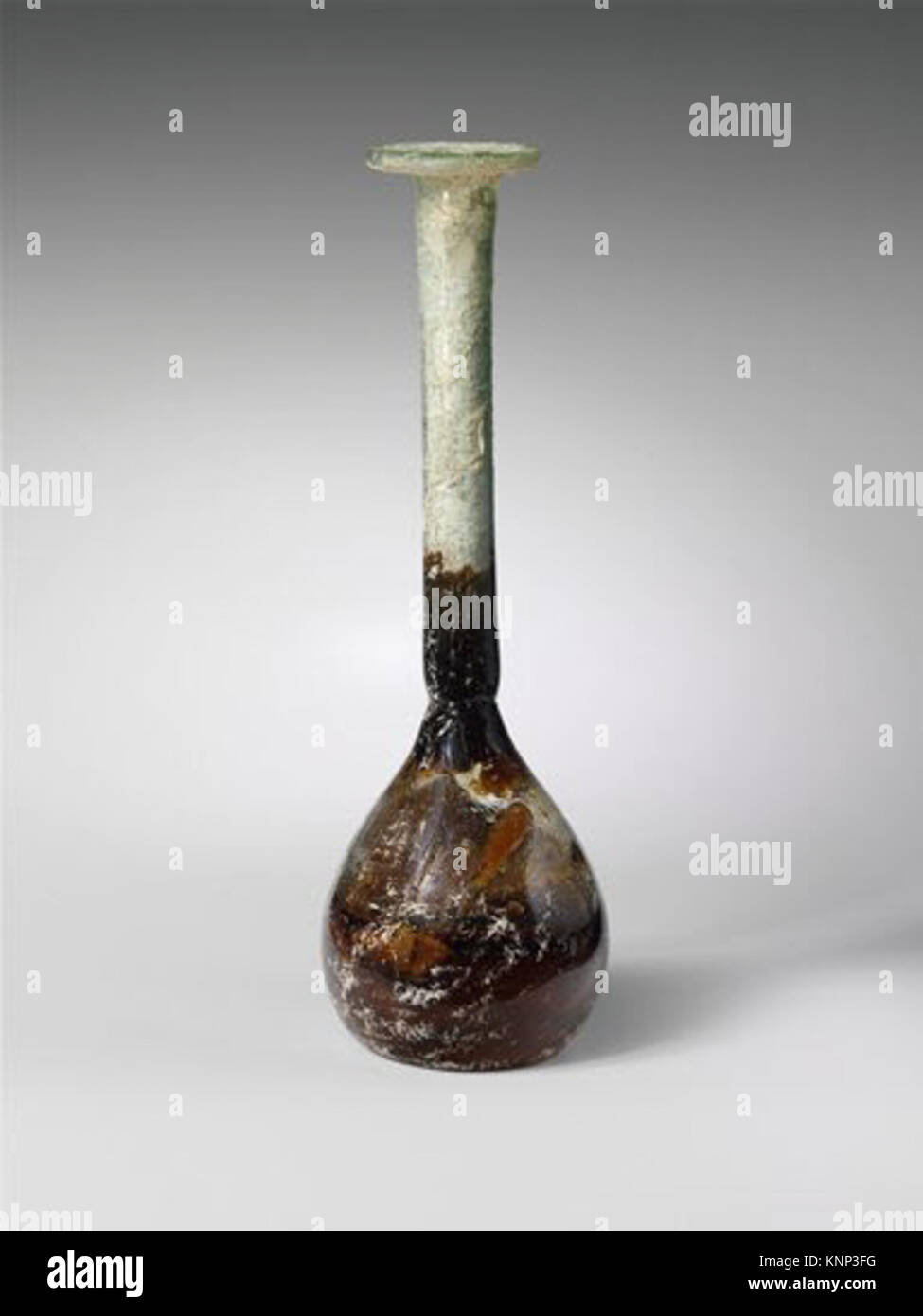 Römische Glasparfümflasche aus dem 2. Bis 3. Jahrhundert n. Chr., mit zylindrischem Hals, kugelförmigem Hockkörper und schrägem, umgeklapptem Rand. Abmessungen: 16,1 cm Höhe, 5,2 cm Durchmesser. Die Flasche ist intakt mit Nadelblasen, Stumpfbildung, Lochfraß und Flecken von brillant schillernder Witterung auf der Außenseite, Bodenverkrustungen und cremebraunen Witterungseinflüssen auf der Innenseite. Stockfoto