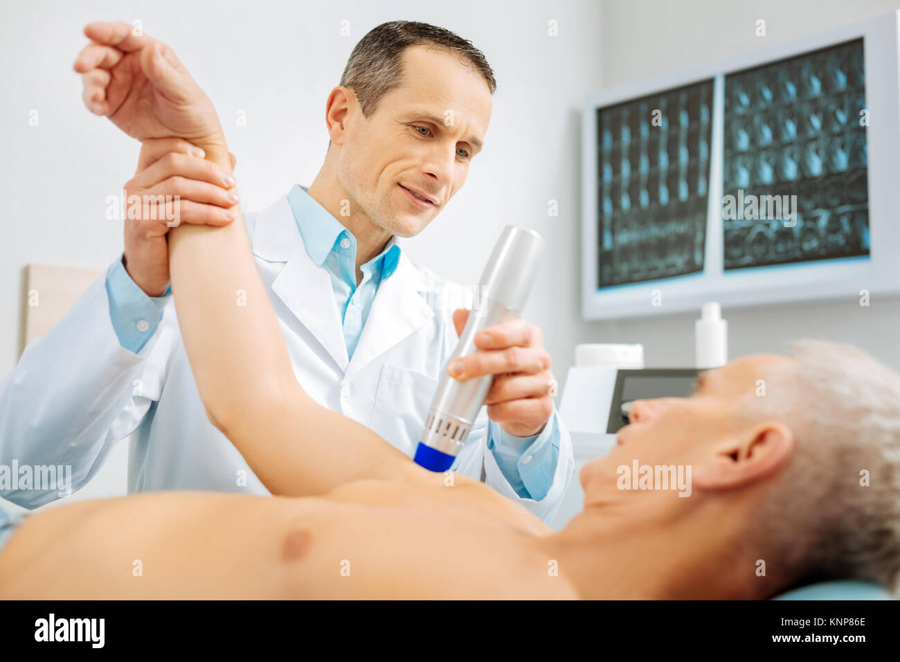 Professionelle männlichen Arzt seine Patienten arm Verbiegen Stockfoto