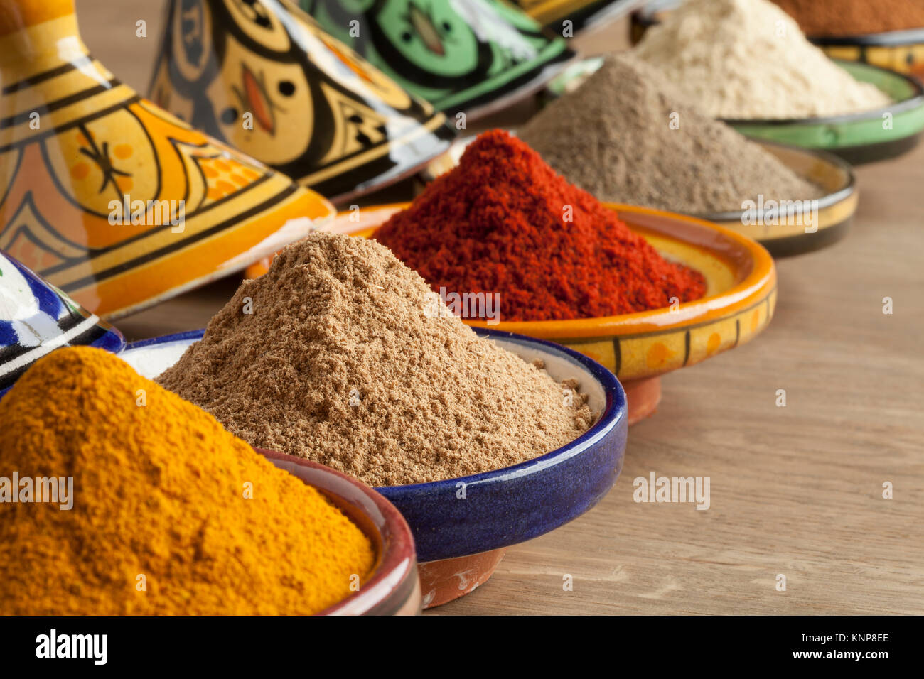 Vielfalt der marokkanischen Pulver Kräuter in farbenfrohe Keramik tajine Nahaufnahme Stockfoto