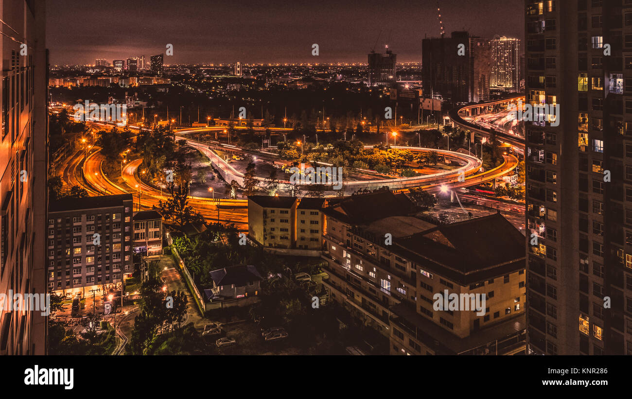 Blick auf die Autobahn von Bangkok aus mit bunten Ampel während der Rush Hour in der Nacht von einem Wolkenkratzer Stockfoto