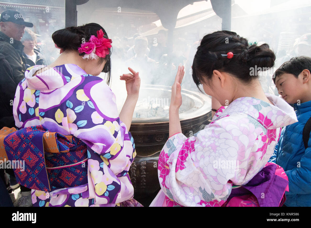 Mädchen in Kimonos wafting Rauchopfer auf sich selbst abgebildet außerhalb des Sensō-ji, historischen buddhistischen Tempel in Tokio. Stockfoto