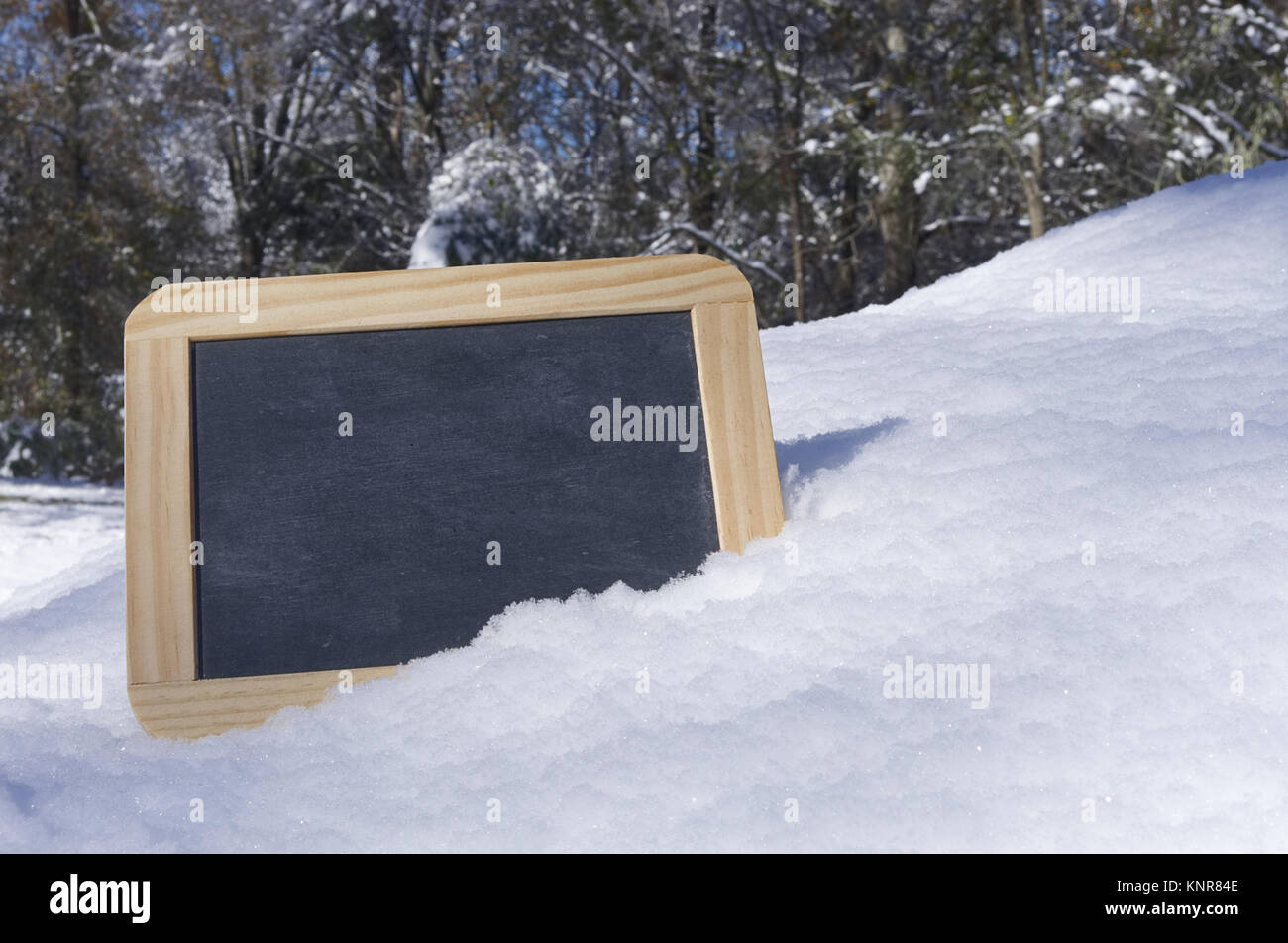 Leere Schiefertafel im Schnee mit Platz für Ihren Text Stockfoto