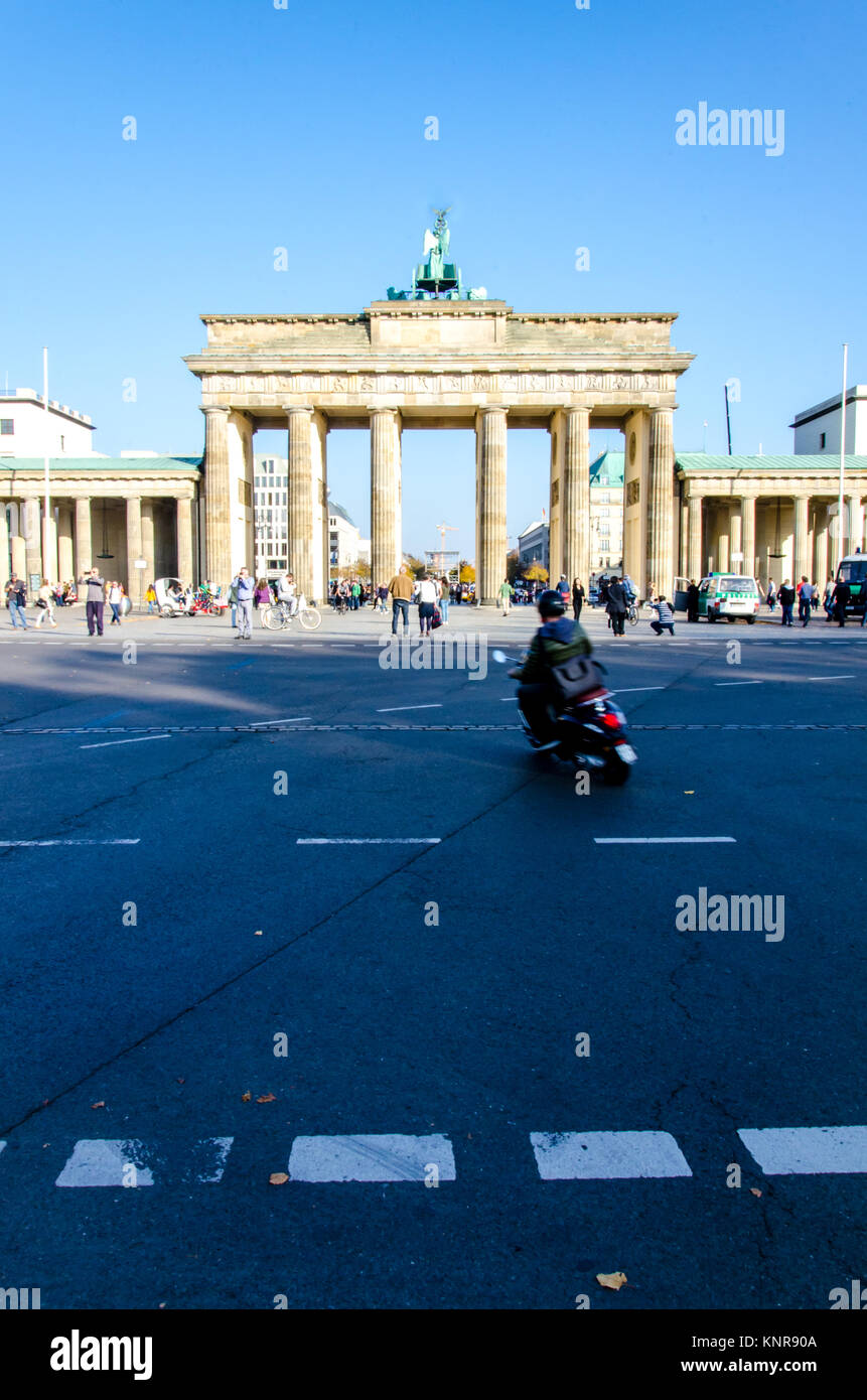 Brandenburger Tor und Roller Fahrer an sonnigen Tag. Hochformat. Travel Poster Cover Hintergrund. Stockfoto