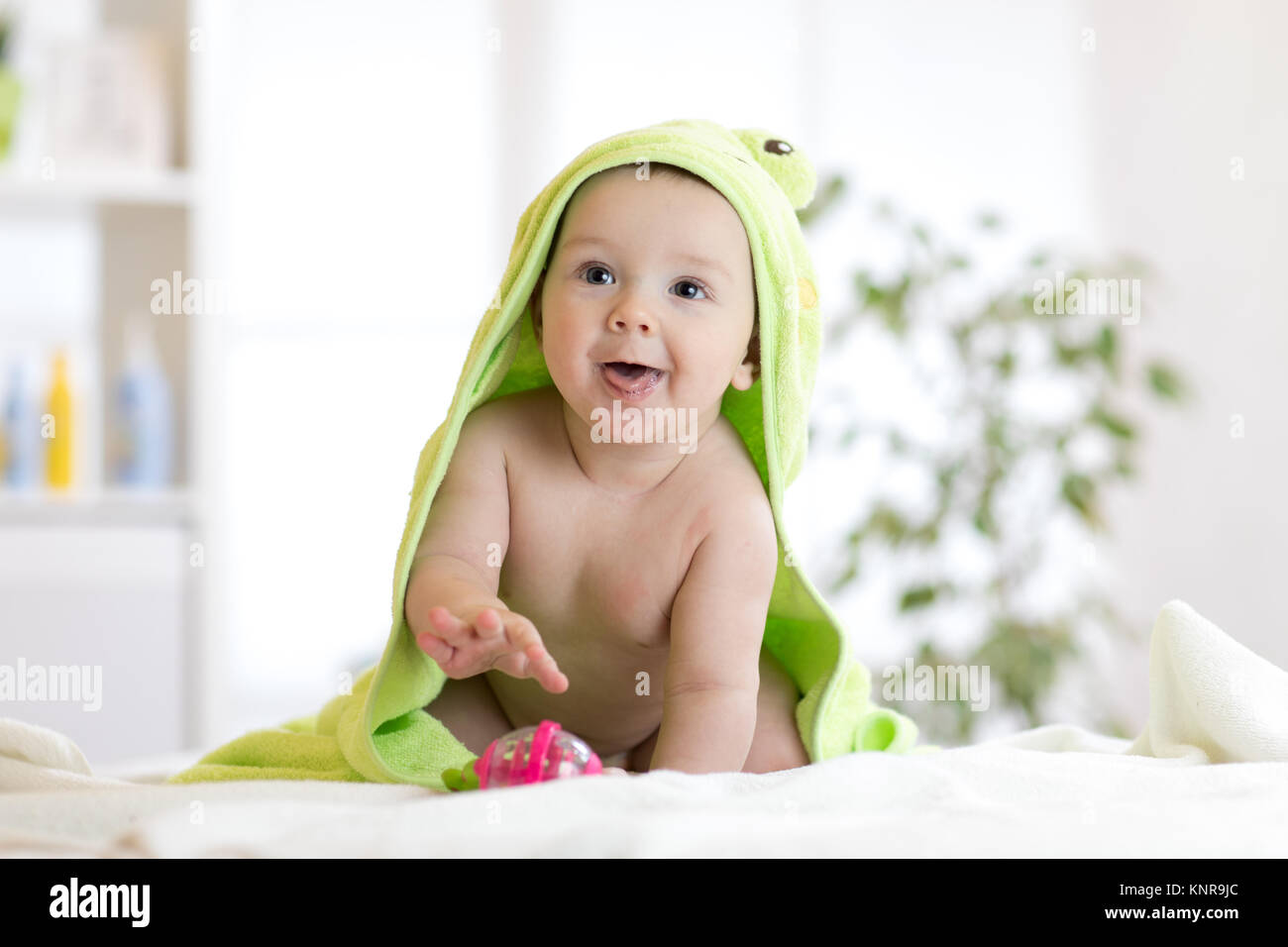 Baby Boy das Tragen von Windeln und grün Handtuch in Weiß sonnig Schlafzimmer. Stockfoto