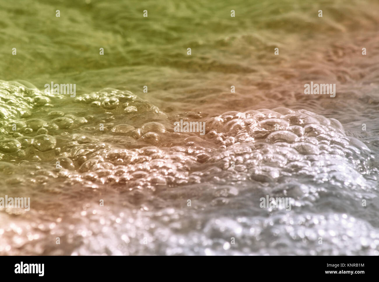 Wasser mit weichen Blasen auf Ufer rollen Stockfoto