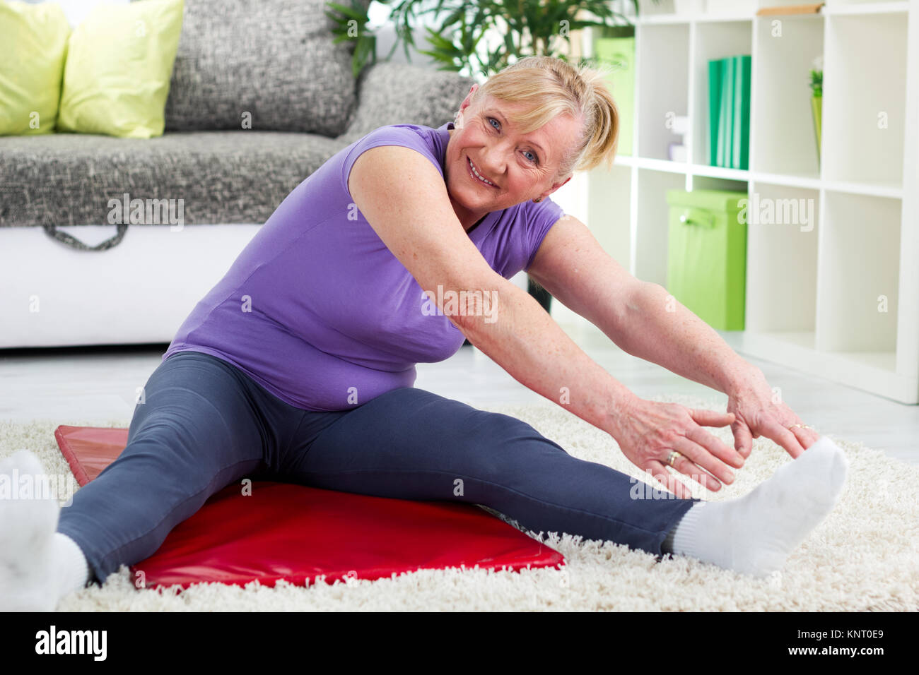 Ältere Frau zu Hause trainieren und lächelnd Stockfoto