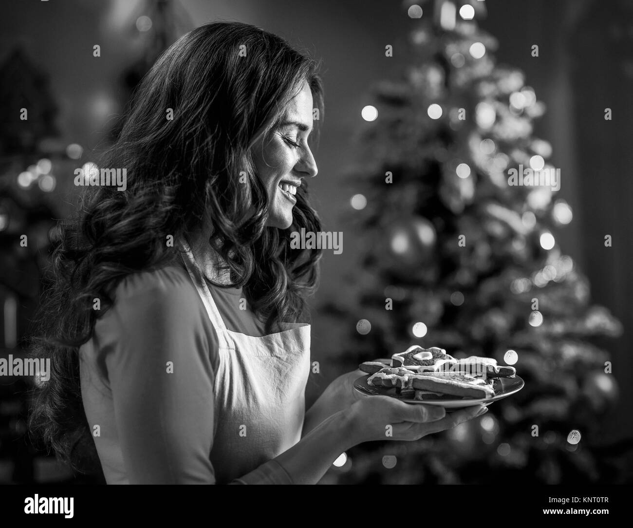 Glückliche junge Hausfrau zeigt Weihnachtsplätzchen Stockfoto