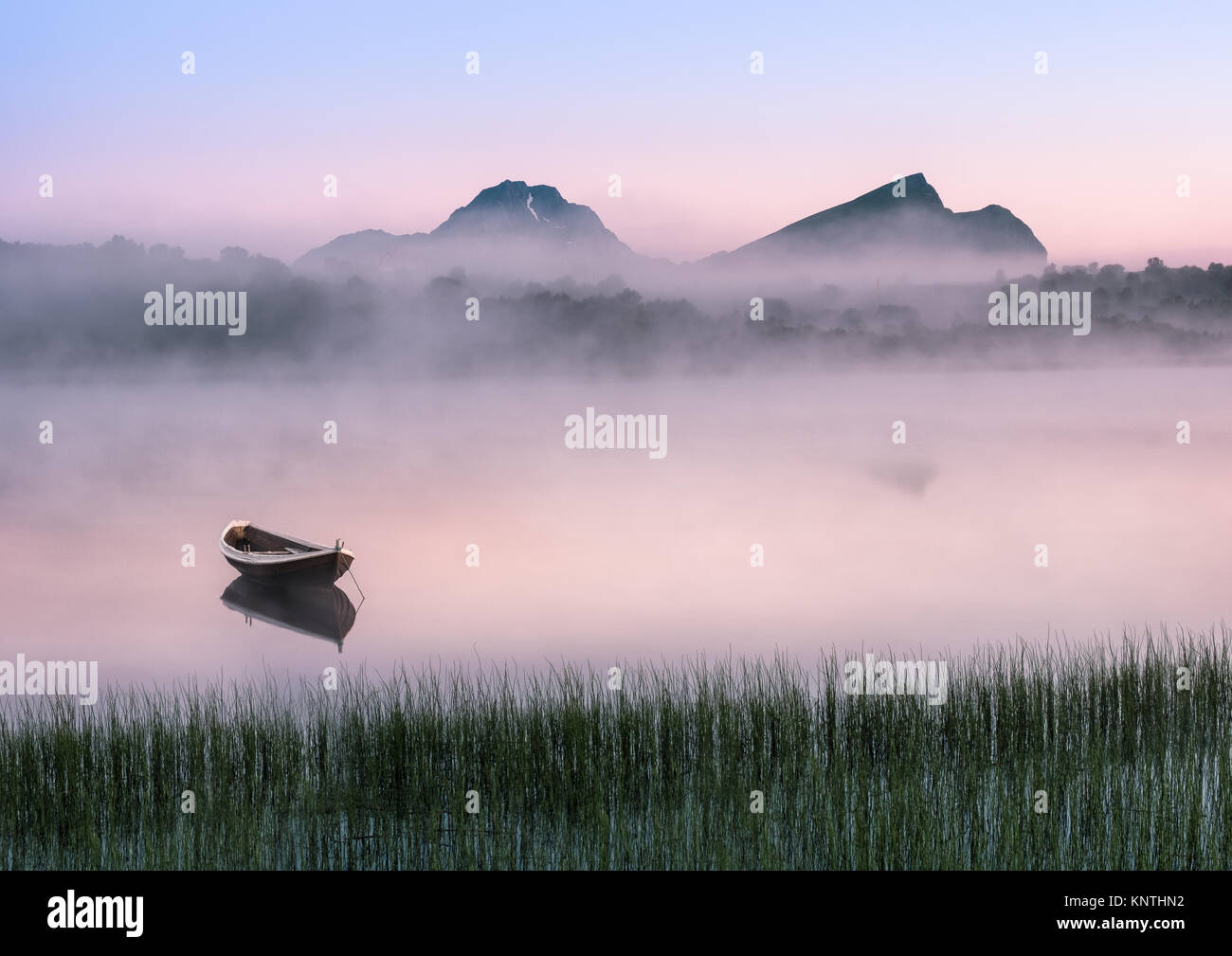 Sehr friedliche Sommernacht mit hölzernen Boot und Nebel auf den Lofoten, Norwegen Stockfoto