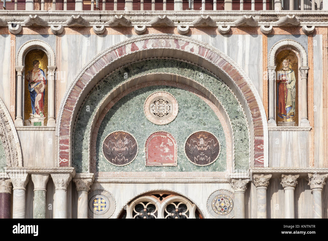 Architektonische Detail der Fassade der Basilika San Marco, Venedig, Italien mit Einlegearbeiten aus Mauerwerk, geschnitzte Kapitelle, Säulen und Nischen mit goldenen Stockfoto