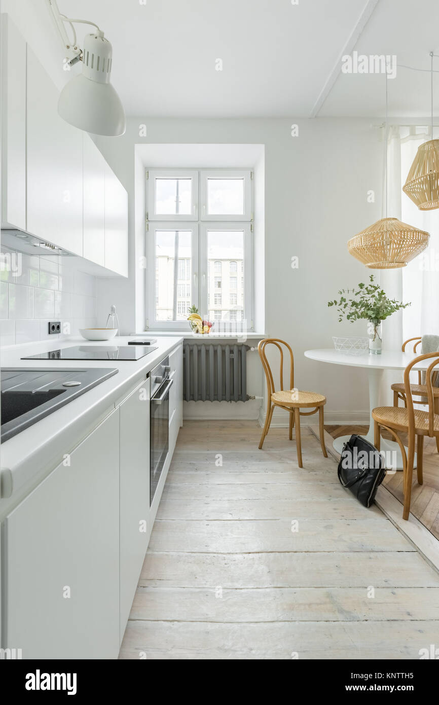 Tisch und Rattanstühle in Küche mit Holz- Lampen dekoriert Stockfotografie  - Alamy