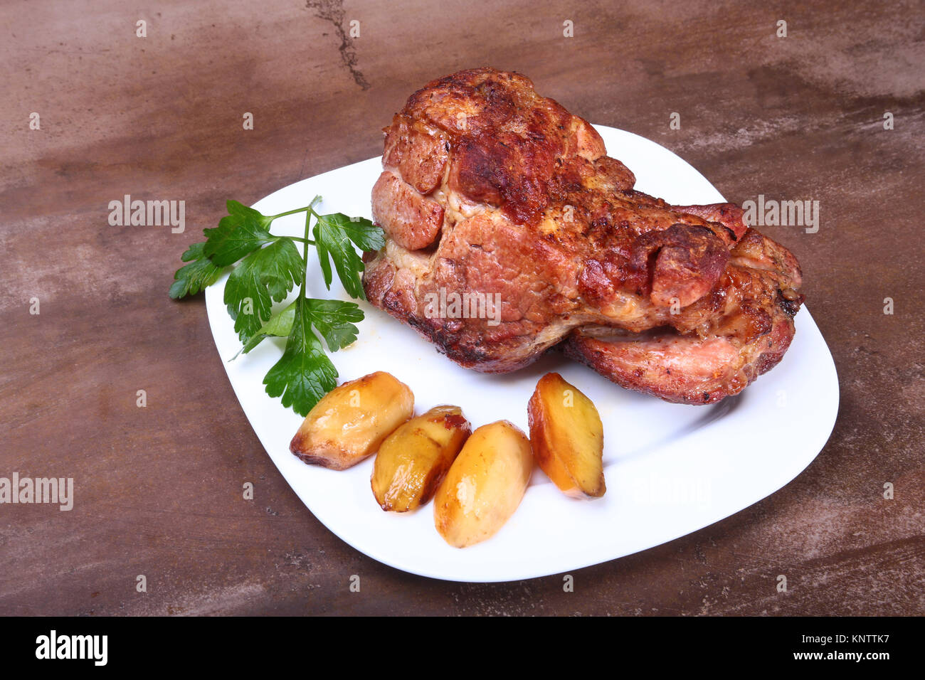 Saftige Schweinekamm Koteletts werden mit Kartoffeln auf einem weißen ...