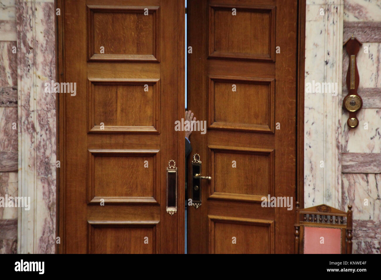Halb geöffneter Tür durch einen Mann, der nur widerwillig, die versuchen, den Raum zu betreten. Im griechischen Parlament in Athen, Griechenland. Stockfoto