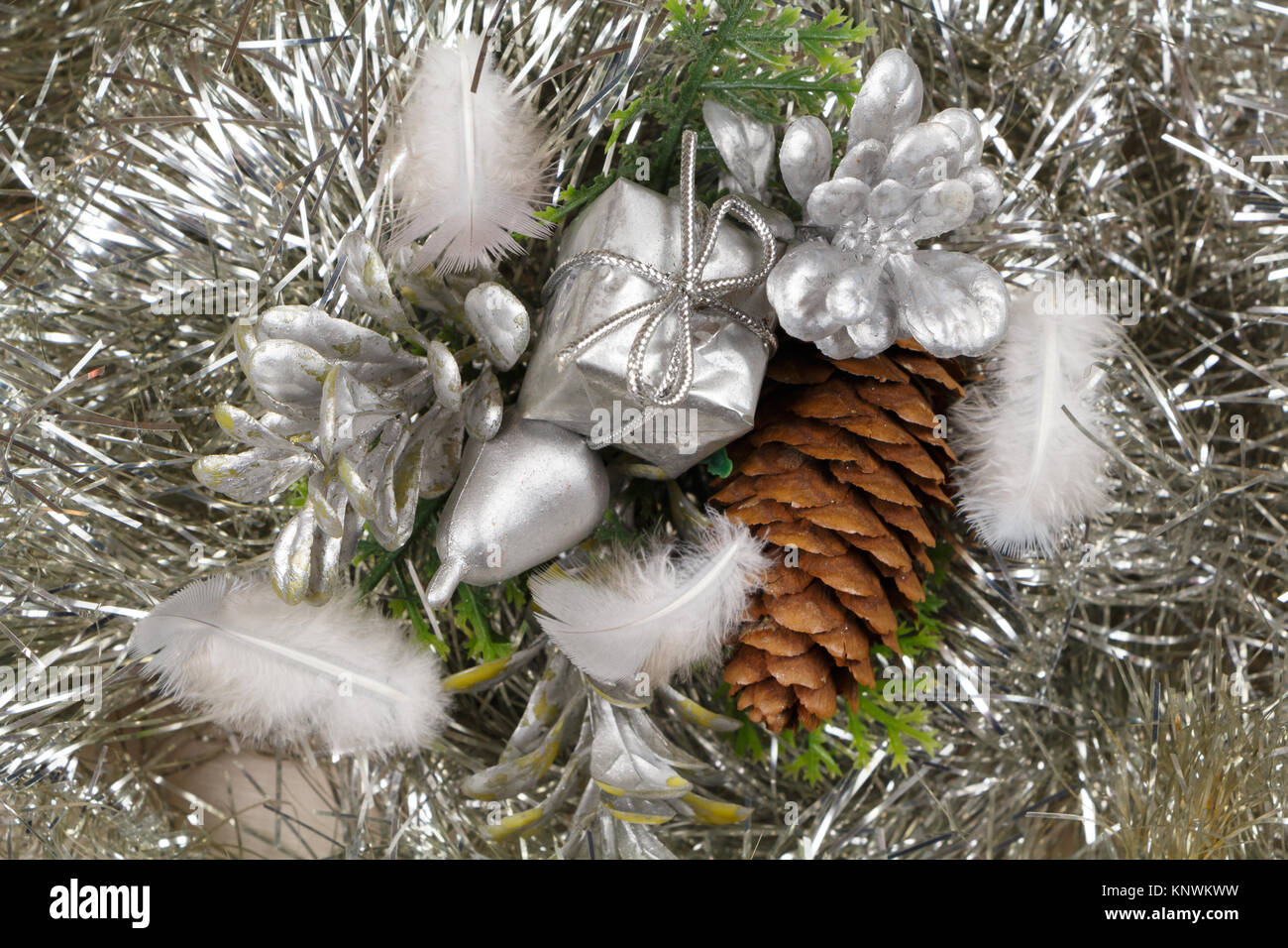 Geschenk und Tannenzapfen auf Silbernem lametta als Dekoration für Weihnachten Stockfoto