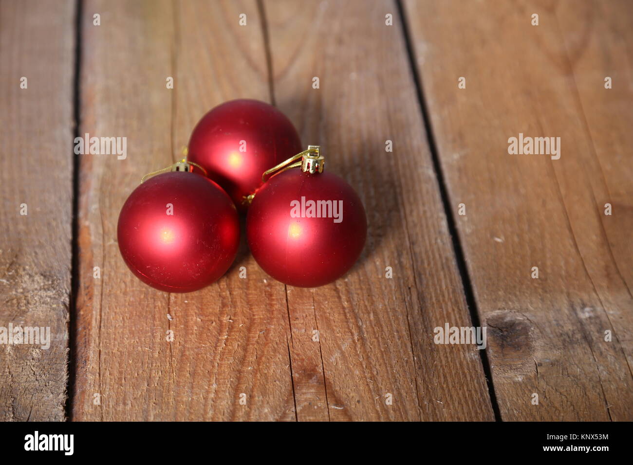 Drei rote Weihnachtskugeln über Holz- Hintergrund Stockfoto