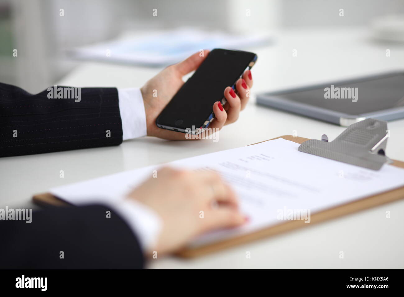 Unternehmerin über Ihr Telefon im Büro auf dem Schreibtisch Stockfoto
