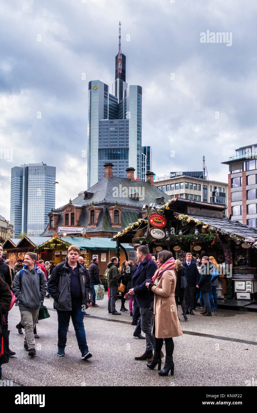 Deutschland, Frankfurt, Leute genießen deutsche Marktstände vor alte Hauptwache Gebäude mit neuen Commerzbank Tower im Hintergrund Stockfoto