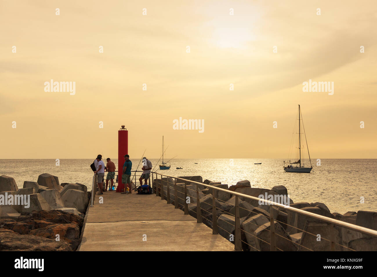 Fischer am Ende des Piers, bei Sonnenuntergang auf Bikini Bay, Sal, Salinas, Kap Verde, Afrika Stockfoto