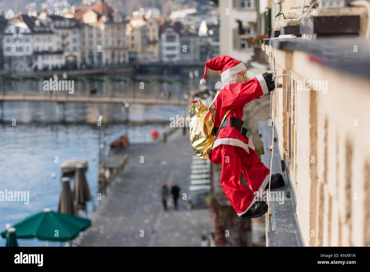 Luzern, Schweiz - 3 Dec 2017: als Weihnachtsschmuck, ein Weihnachtsmann  Marionette mit Weihnachtsgeschenke klettert die Fassade eines Hauses in  Luce Stockfotografie - Alamy