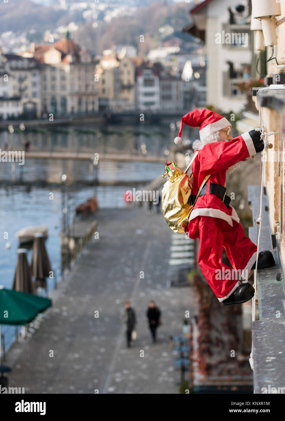 Luzern, Schweiz - 3 Dec 2017: als Weihnachtsschmuck, ein Weihnachtsmann  Marionette mit Weihnachtsgeschenke klettert die Fassade eines Hauses in  Luce Stockfotografie - Alamy