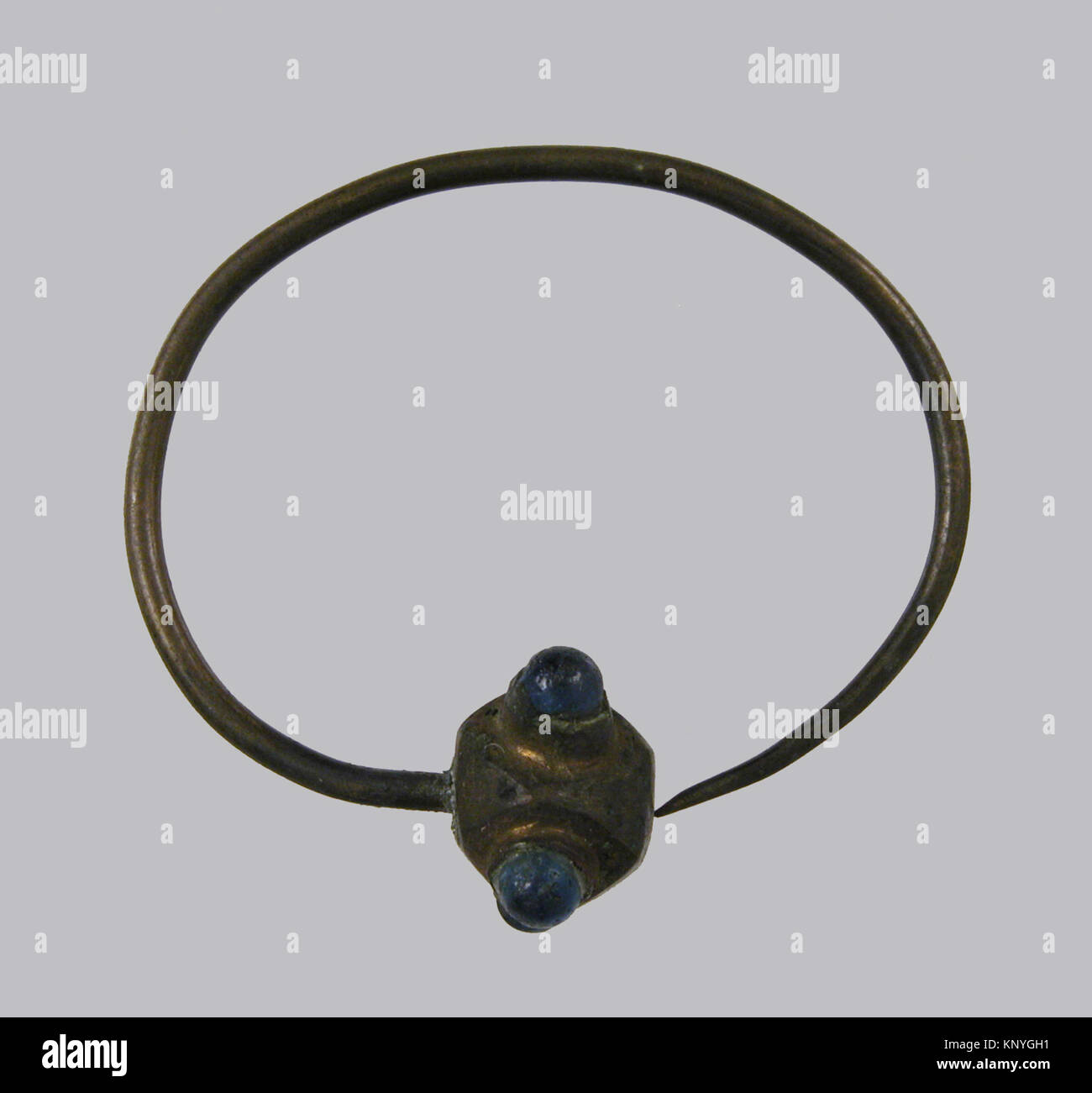 Dieser fränkische Ohrring aus den Jahren 500–700 CE besteht aus Kupferlegierungen, vergoldeten Cabochons und Glaspasten, die das frühmittelalterliche Schmuckhandwerk und ornamentales Design widerspiegeln. Stockfoto