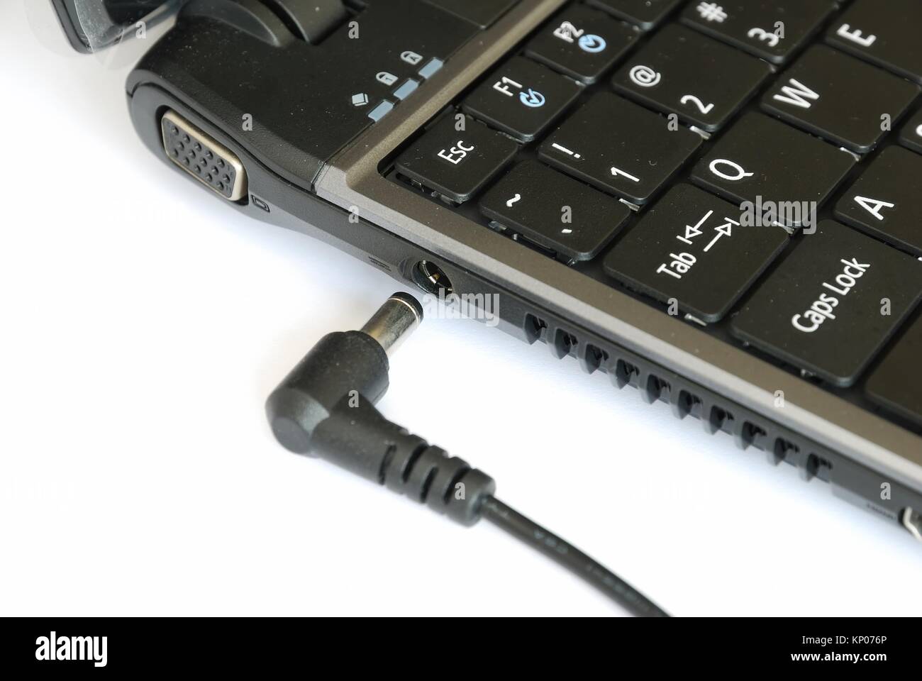 Anschluß Stromversorgung anschließen an Notebook auf weißem Hintergrund. Für Computer, Elektronik und Energie- und Technologiekonzepte. Stockfoto