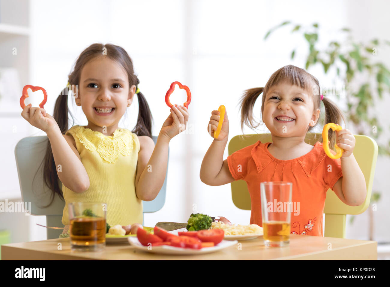 Lustige Kinder spielen und essen im Kindergarten Stockfoto