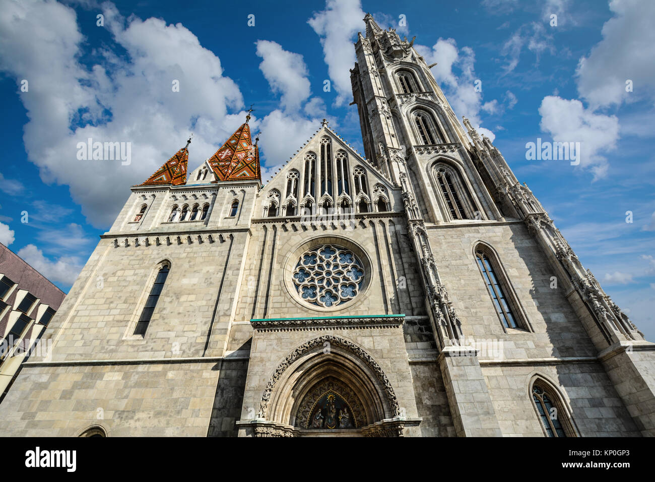 Die Fassade und Rosette der Matthiaskirche in Buda Castle's Komplex in Budapest Ungarn an einem sonnigen Tag Stockfoto