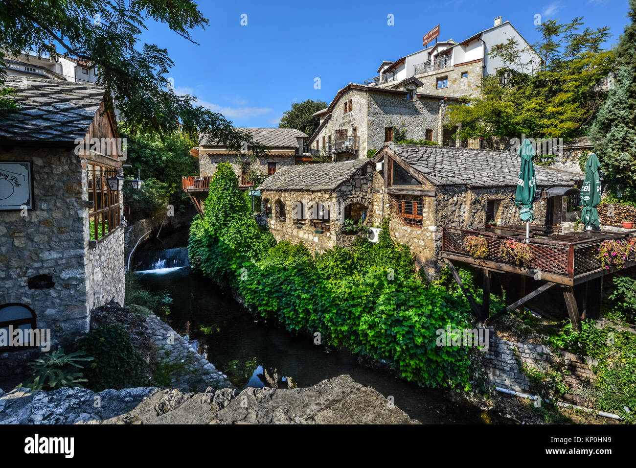 Eine friedliche Stream vom Fluss Neretva mit einem Stein Haus, kleines Cafe und Gärten in Mostar, Bosnien und Herzegovinia Stockfoto