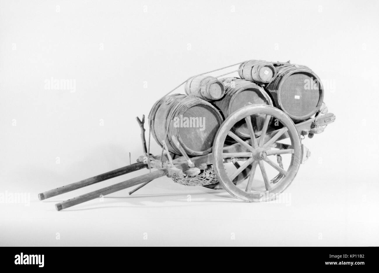 Diese Illustration aus einem antiken Buch zeigt einen Wagen mit Fässern, der historische Transportmethoden widerspiegelt. Das Kunstwerk dient als visuelle Aufzeichnung vergangener Epochen und erfasst das utilitaristische Design des Wagens und der Fässer, die er trägt. Die Szene ist im Vintage-Stil dargestellt, typisch für den künstlerischen Ansatz dieser Zeit. Stockfoto