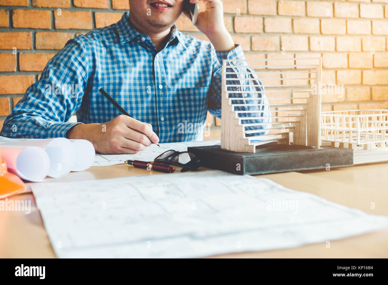 Architekt oder Ingenieur im Gespräch über Smart Phone arbeiten im Büro auf einer Blaupause. Architekten Arbeitsplatz Stockfoto