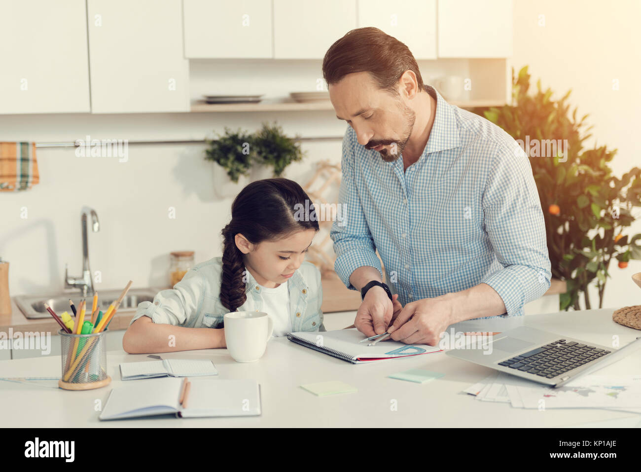 Smart netter Mann seiner Tochter helfen bei Hausaufgaben Stockfoto