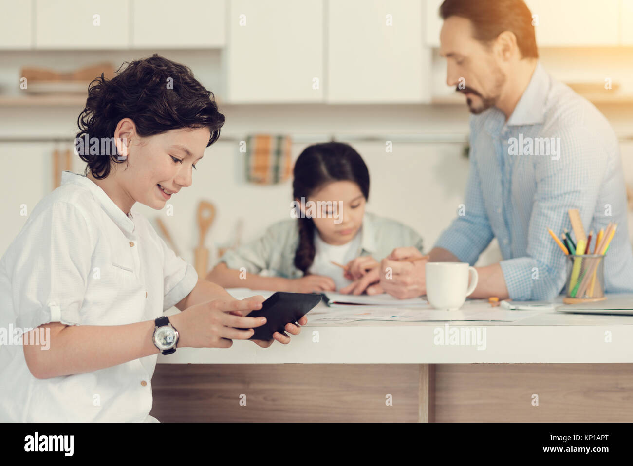 Fröhliche positive Junge spielt auf einem Tablet Stockfoto