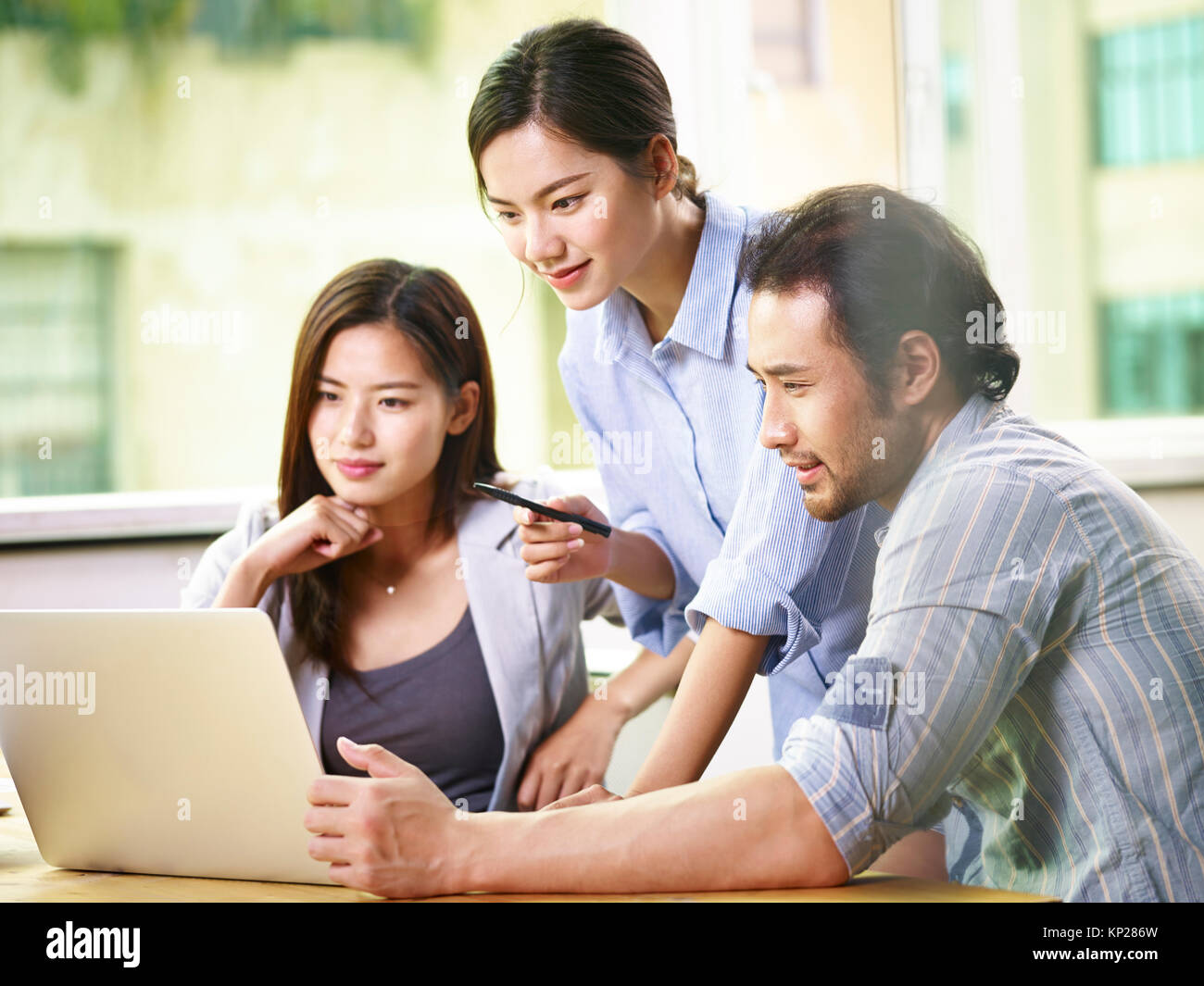 Team von jungen asiatischen Geschäftsleuten in Freizeitkleidung zusammen arbeiten im Büro mit Laptop Computer. Stockfoto