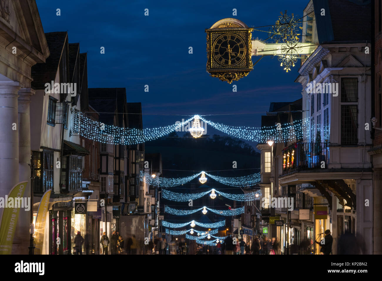 Die Hohe Straße in Guildford mit Weihnachtsbeleuchtung und die berühmten Guildhall gold Uhr in der blauen Stunde auf einem Late night shopping Tag, England Großbritannien Stockfoto
