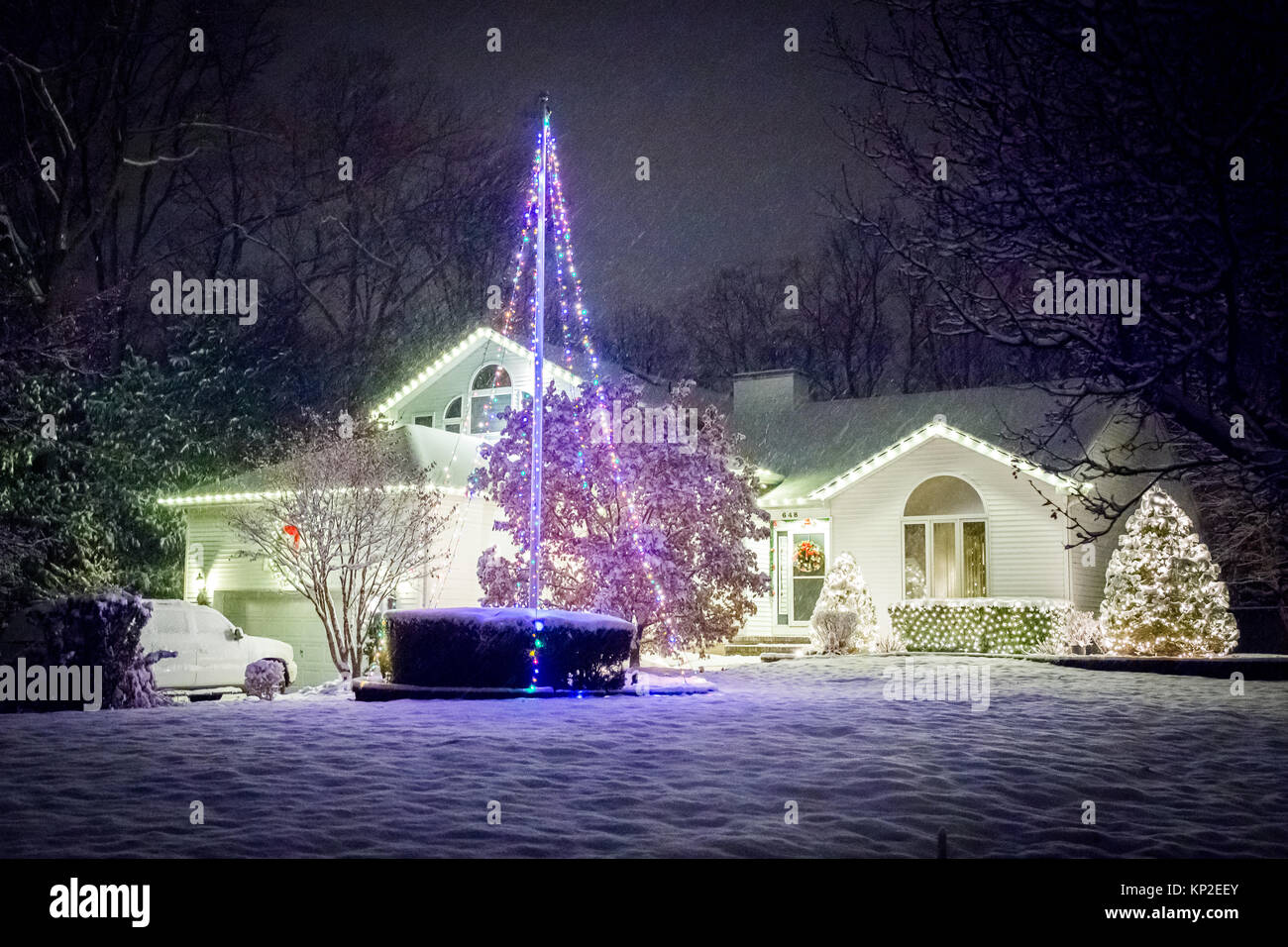 Eingerichtete Haus für Weihnachten in der Nacht in Schnee bedeckt Stockfoto