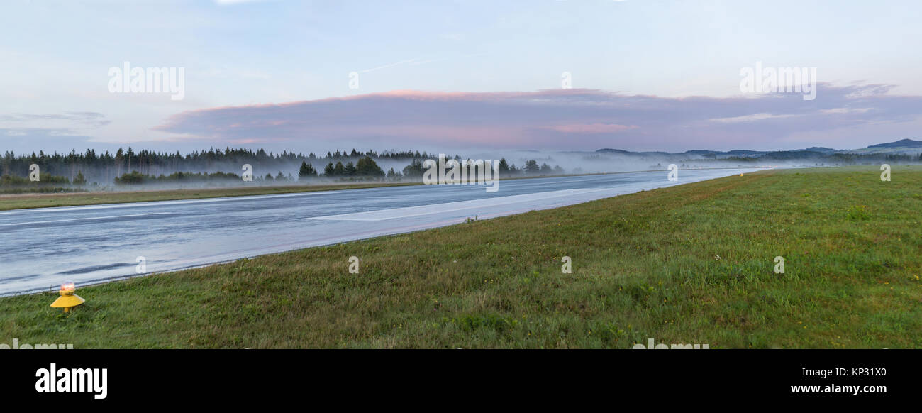 Leer Start- und Landebahn am Flughafen während Nebel Sonnenaufgang. Neblig und Landebahn. Stockfoto