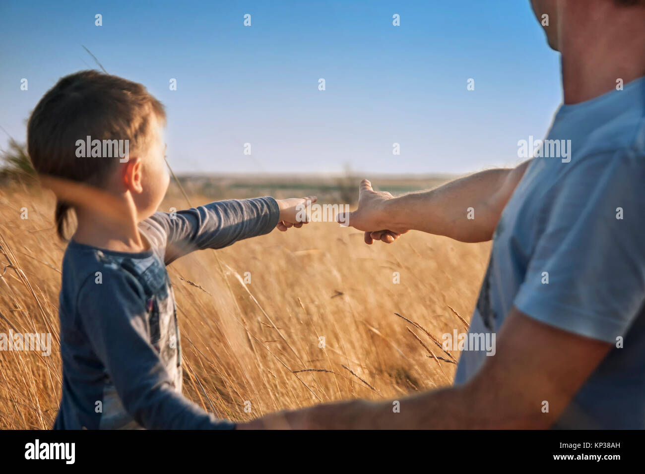 Vater und Sohn in das Feld bei Sonnenuntergang, Punkt Finger am Horizont, schauen Fern, Familie, Emotionen, Foto, Effekt Instagram, Rückansicht Stockfoto