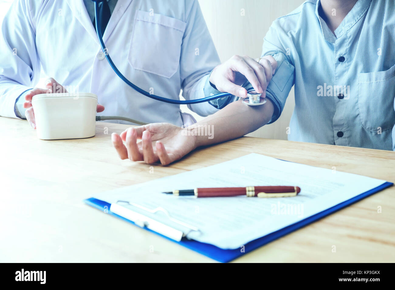 Arzt Messung des arteriellen Blutdruck Frau am Arm des Patienten medizinische Versorgung im Krankenhaus Stockfoto