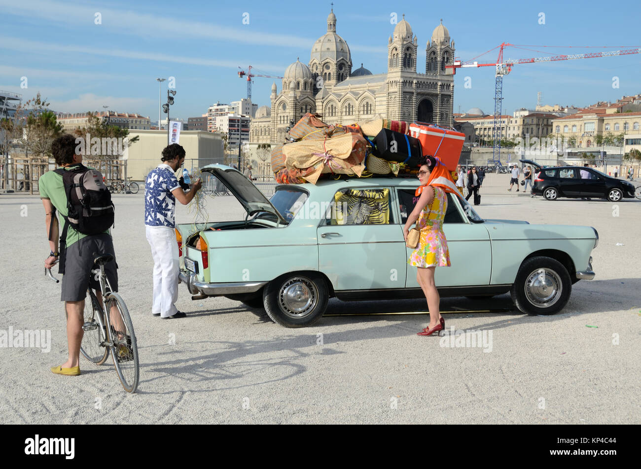 Paar Touristen Verpackung Oldtimer mit Gepäck & Koffer vor marselle Kathedrale, Marseille, Provence, Frankreich Stockfoto