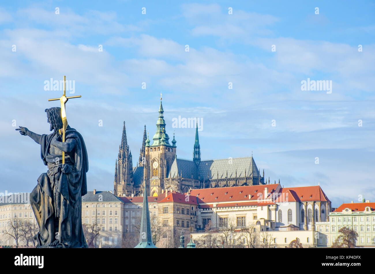 Religiöses Statue auf der Karlsbrücke mit St. Vitus Kathedrale im Hintergrund Stockfoto