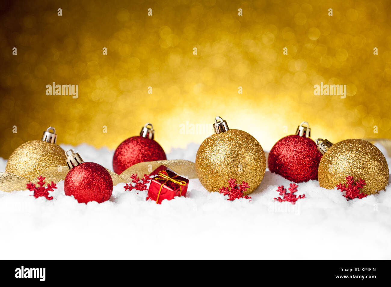 Vielen bunte Weihnachten Dekoration Kugeln im Schnee auf goldenem Hintergrund Stockfoto