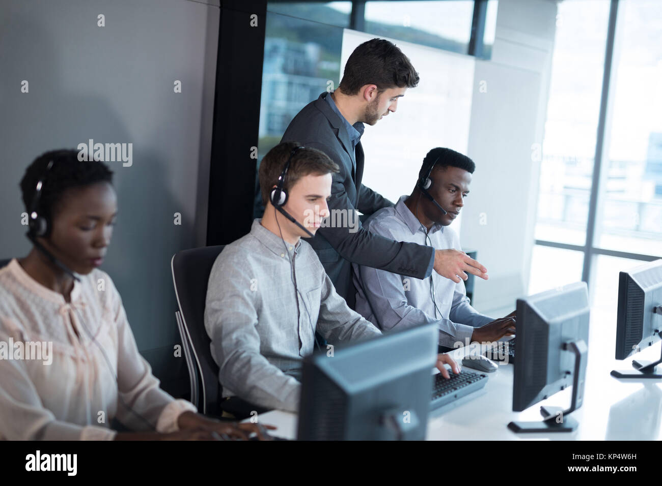 Customer Service Executive Trainer ihr Team Überwachung im Büro Stockfoto