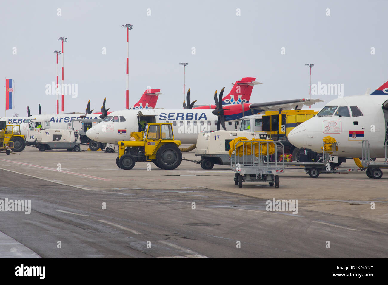 Flotte der geparkten Flugzeuge von Air Serbien ATR 72 Turboprop und Bodenabfertigung Traktoren auf internationaler Flughafen Nikola Tesla in Belgrad, Serbien Stockfoto