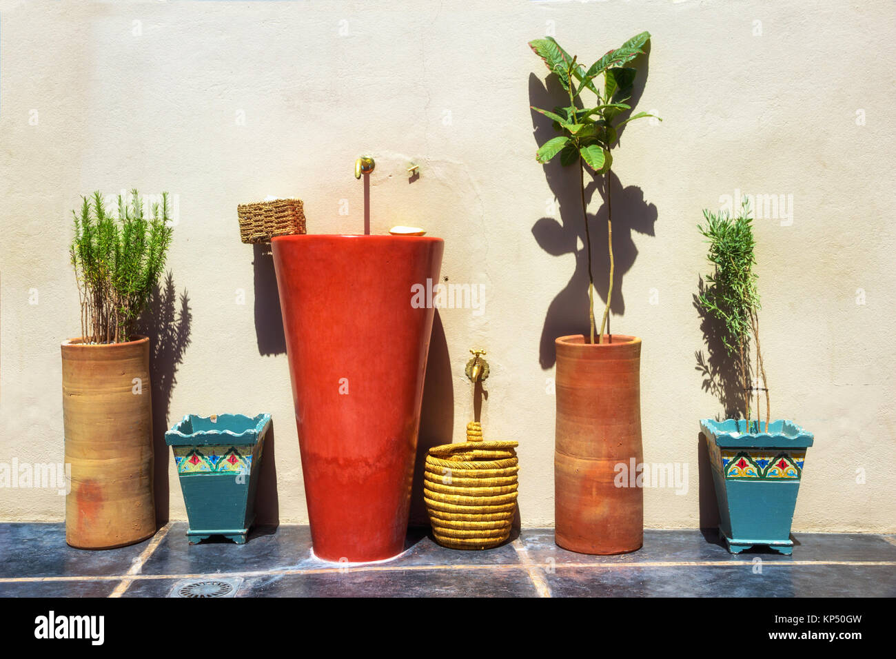 Deco Waschbecken und Pflanzen gegen eine Wand in einem mediterranen Land. Stockfoto