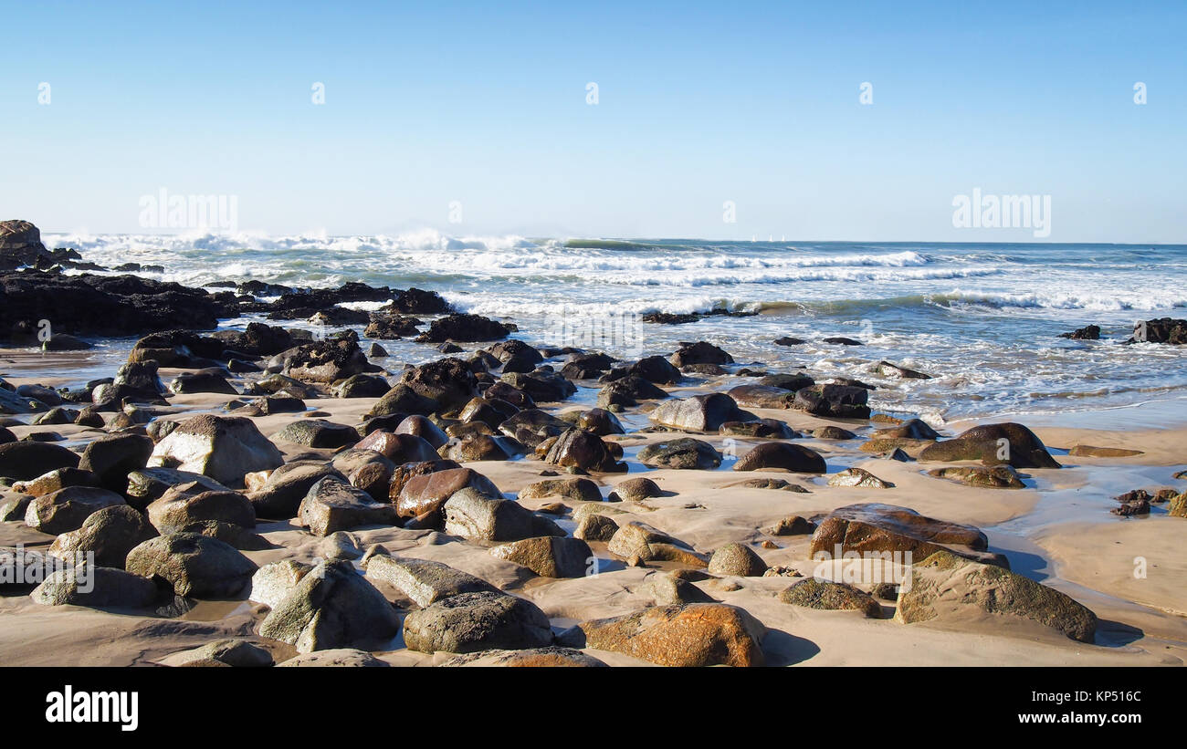 Felsbrocken am Strand von Atlantic Ocean Surf in Porto, Portugal Stockfoto