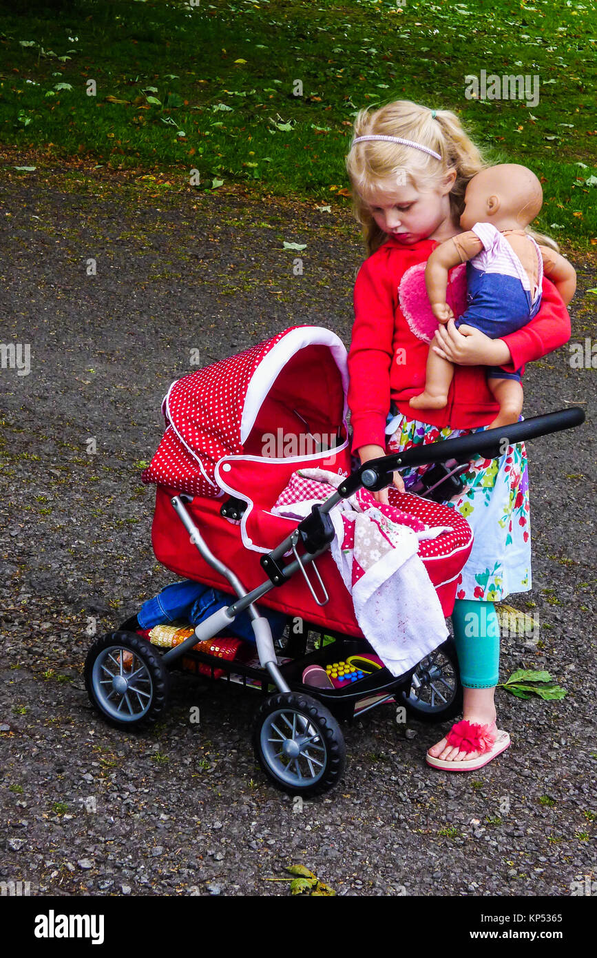 Kleines Mdchen, Kind, spielt mit ihrer Puppe und Kinderwagen, Schlitten im  Park, Kinder Spielzeug Kinder Spielzeug spielen Zeit Stockfotografie - Alamy