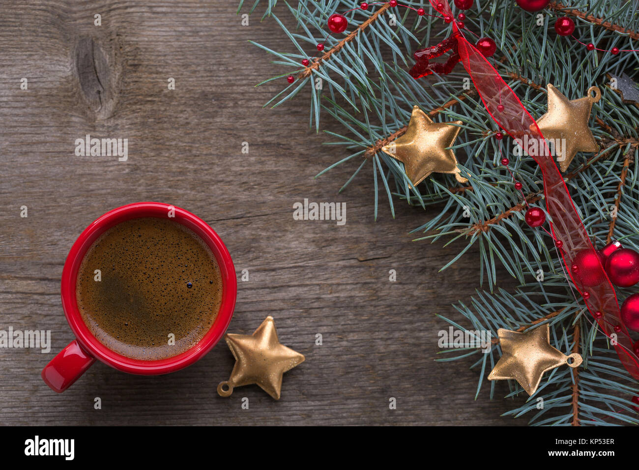 Rot Tasse Kaffee und tanne Zweig mit Weihnachtsschmuck auf alten Holz- Hintergrund. Stockfoto