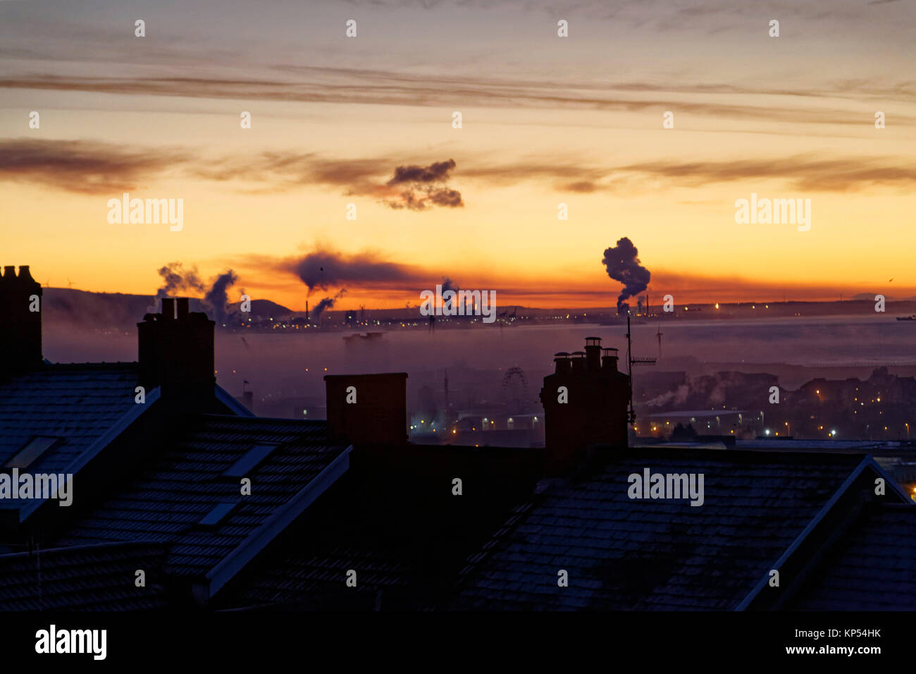 Rauch von Port Talbot Steel Works wird in der Horizont sichtbar, über Dächer während einer frühen eisigen Morgen in Swansea, Wales, UK gesehen. Dienstag, 12. Dez. Stockfoto