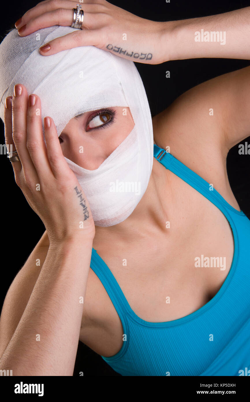 Weibliche hält Gesicht Erste Hilfe Gaze eingewickelt Kopfverletzung Schmerz Stockfoto